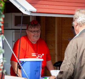 Hymyilevä myyjätär torikojussa