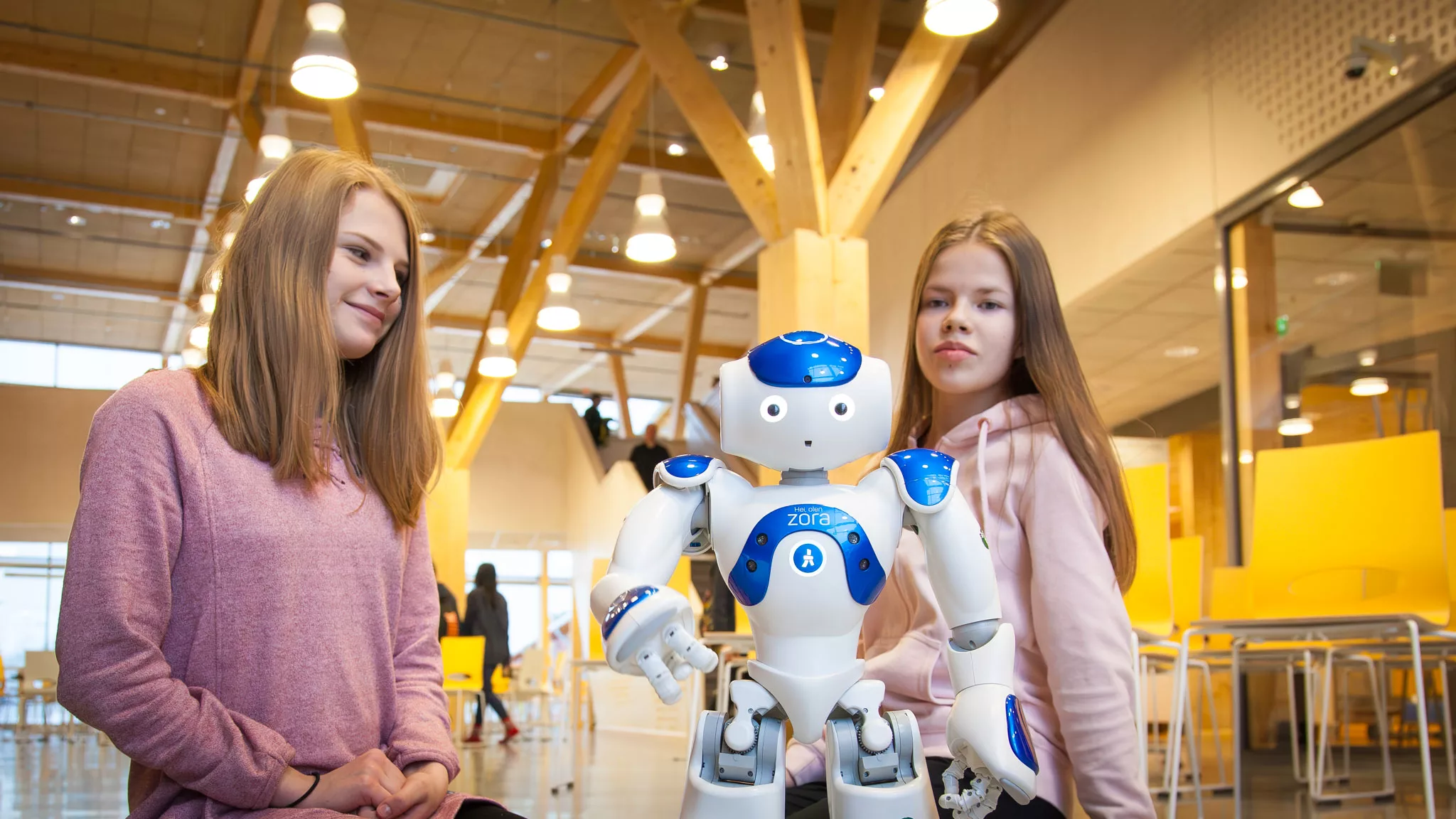 Kaksi tyttöä robotin kanssa